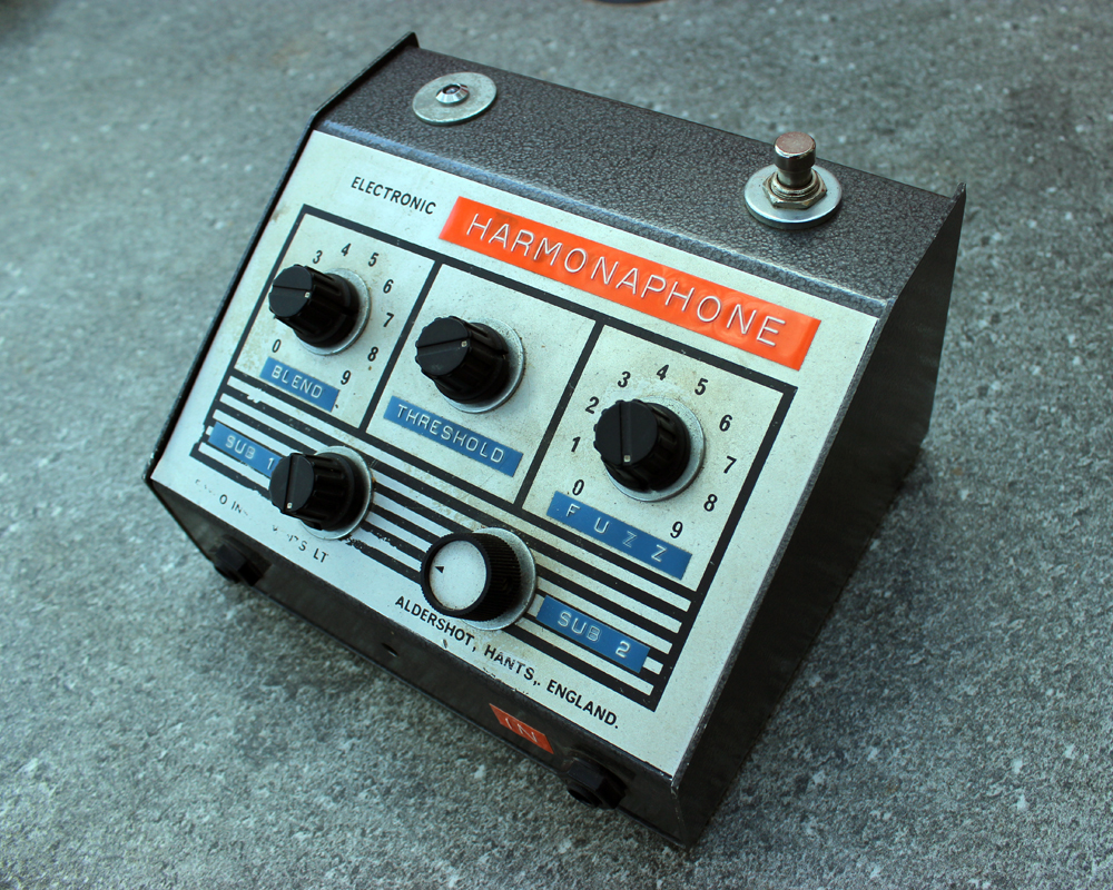 A hand made electronic fuzz pedal: upright metal enclosure, knobs, dials, dymo labelling, a big switch on the top