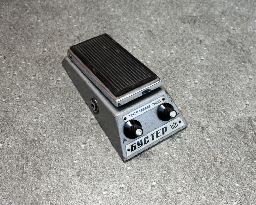 Vintage guitar fuzz pedal, metal, with a treadle and two knobs, labelling in cyrillic text, looks like a little creature