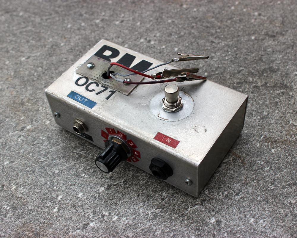 A modified hand-made pedal in a metal enclosure with knobs, a switch, crocodile clips, wires, and labelled with colourful dymo tape