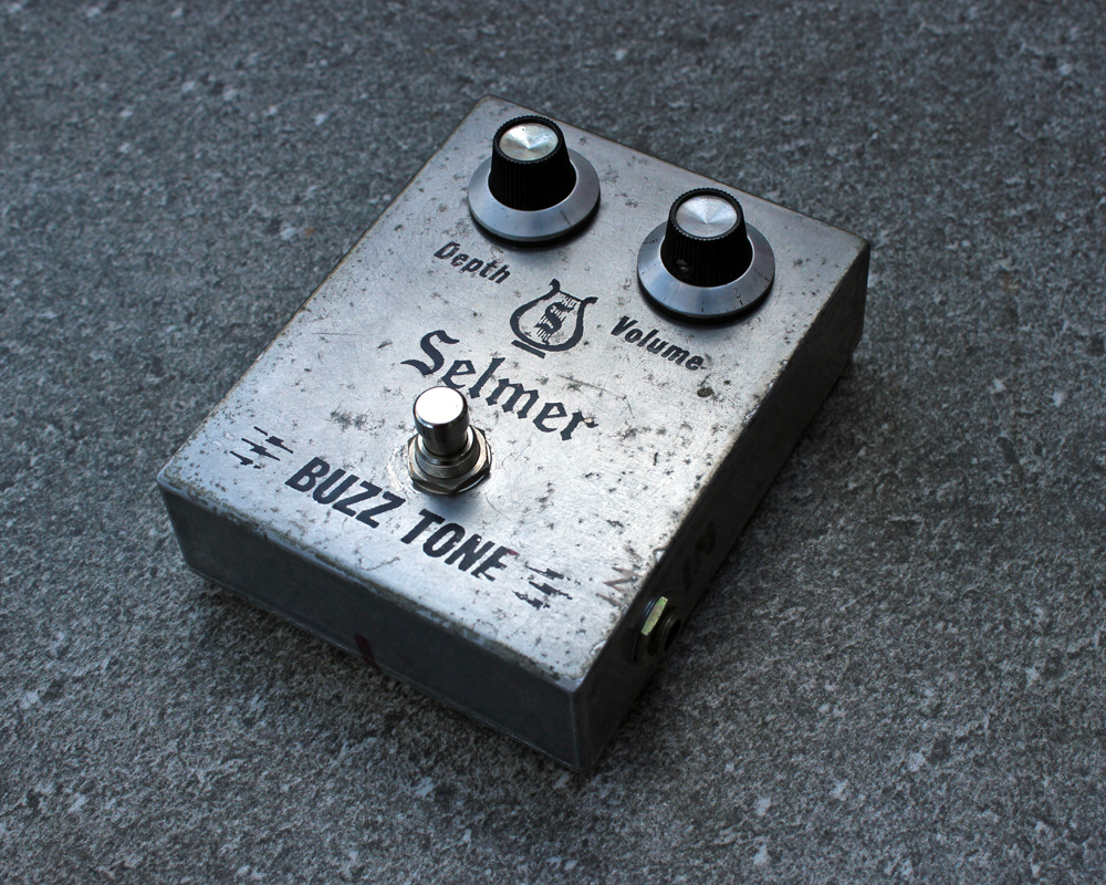 A hand made electronic pedal: two knobs, a button, fucked-up looking, elegant graphical text, looks like a surprised face