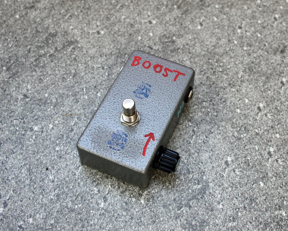 A hand made electronic pedal, neat little fuzzbox with a metal enclosure, minimal knobs and labelled in red pen
