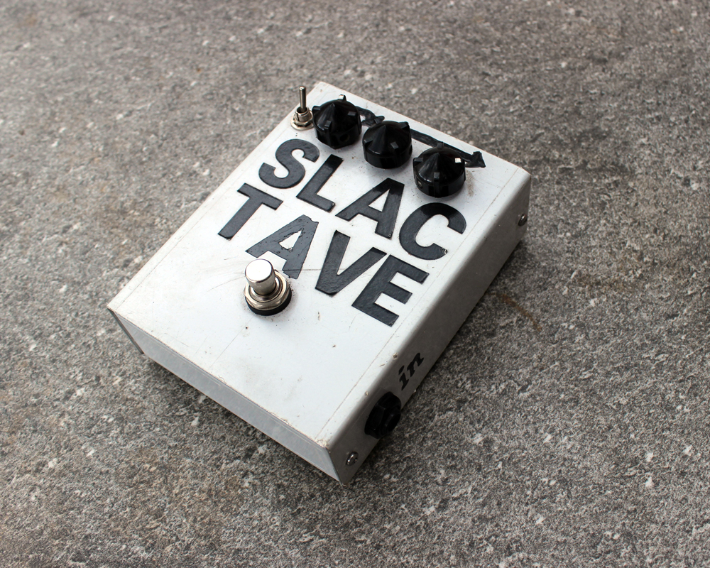 A hand made electronic fuzzbox, metal enclosure, three knobs, two switches, bold lettering