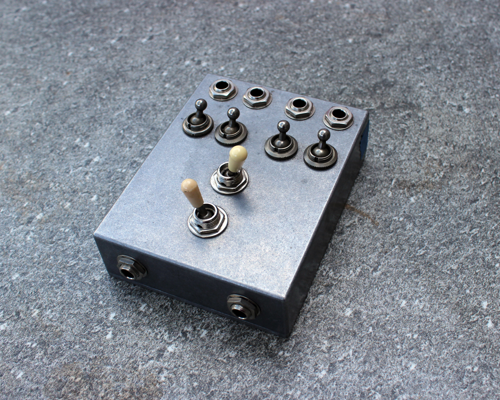 A hand made electronic pedal: metal, six switches, inputs and outputs