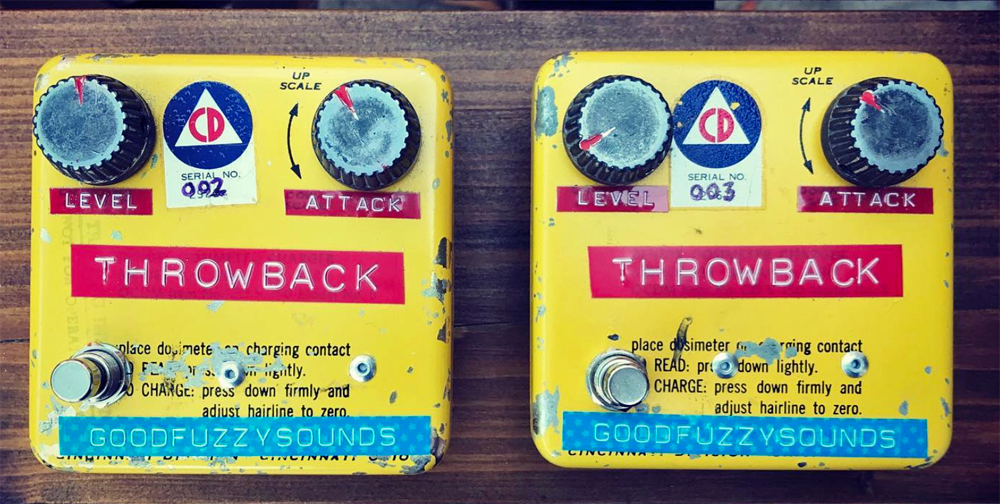 A pair of hand-made fuzz pedals in yellow printed enclosures with two knobs and colourful dymo labels reading level, Attack, Throwback and Good Fuzzy Sounds