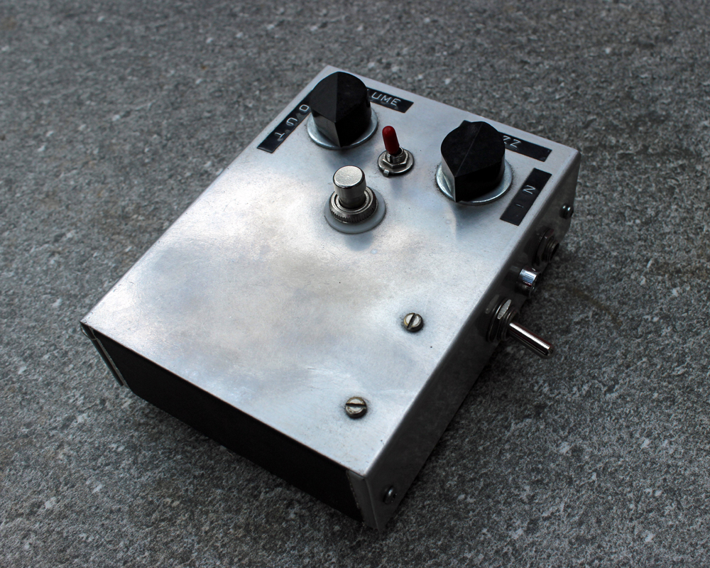 A hand made electronic pedal: metal box, dymo tape, knobs and switches