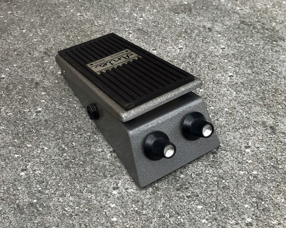 Vintage guitar fuzz pedal, metal, wedge-shaped with a rubber-coated treadle and two knobs on the front like big eyes