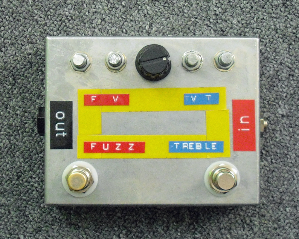 A home made effects pedal in a metal enclosure with colourful Dymo tape labels and a few knobs
