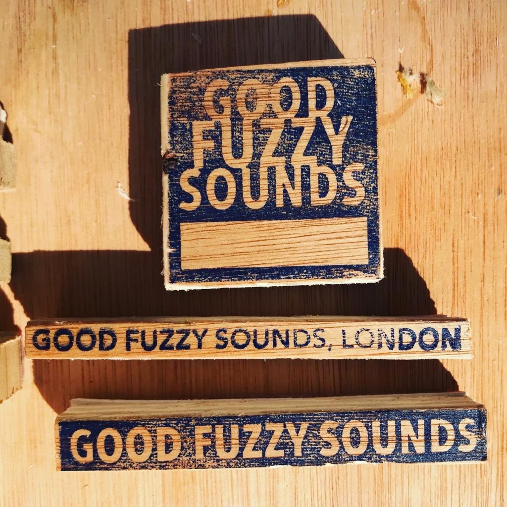 Hand-made printing stamps on small blocks of wood reading Good Fuzzy Sounds, Good Fuzzy Sounds London